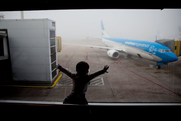 Parents travel with babies on international flight with carry-on essentials